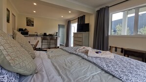 A bedroom with a bed, a desk, a TV, and a window. - Geyser Lookout BnB (Rotorua)