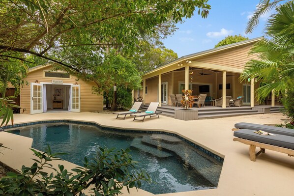 Un espace piscine avec des chaises longues, un patio couvert et un bâtiment portant l’inscription « The Lodge ».