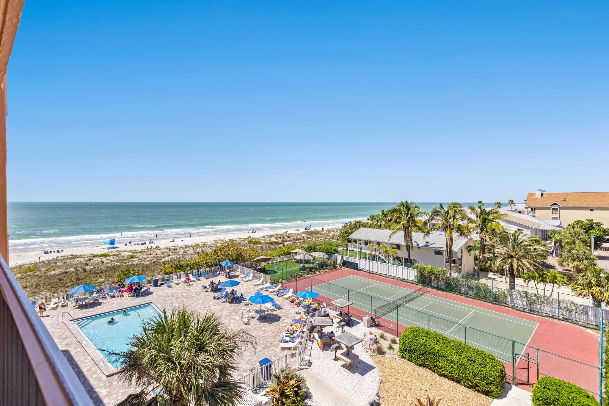 Ein Strandhotel mit Pool, Tennisplatz und Meerblick.