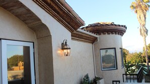 A building with a curved facade, a tiled roof, and a small outdoor seating area with a table and chairs. - Luxurious 3 BD in Culver City with Pool& Hot Spa (Culver City)