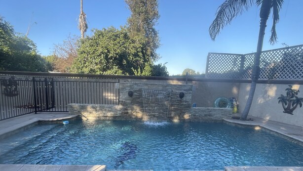 A swimming pool with stone walls and a waterfall feature. - Luxurious 3 BD in Culver City with Pool& Hot Spa (Culver City)