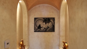 A hallway with a mural of a couple on a beach, two small animal figurines on the walls, and a thermostat on the left. - Luxurious 3 BD in Culver City with Pool& Hot Spa (Culver City)