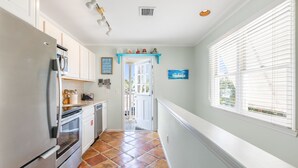 A kitchen with white cabinets, a stainless steel refrigerator, and a tiled floor. - THE QUARTERDECK ~ Colorful & Comfy 2nd Floor 2Ba/ 1Ba Shipyard Unit! (Key West)