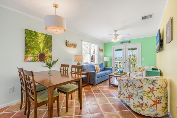 A dining area with a wooden table and chairs, a blue sofa, and a patterned armchair.
