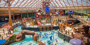 An indoor water park with multiple water slides, inflatable rafts, and a large pool area. - Holiday Skiing and Tubing at Massanutten (McGaheysville)