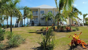 A two-story building with a flat roof and a balcony on the second floor. - AS SEEN ON HGTV!  Lux Condo w/Views, Htd Pool, Beach, Golf Cart, Pickleball (Governors Harbour)