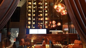 A modern interior with a central seating area, a high ceiling, and decorative lighting.