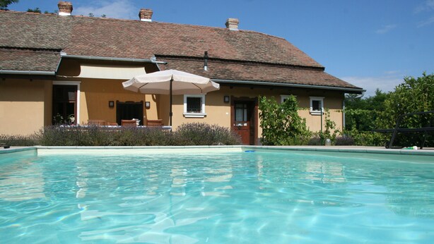 A swimming pool with a house in the background. - Country house, 8 people. Private parking, swimming pool and large private garden. At Lake Tisza. (Tiszaszentimre)