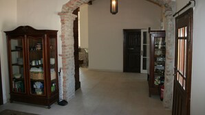 An interior with a brick archway, a wooden cabinet with glass doors, and a door with glass panels. - Country house, 8 people. Private parking, swimming pool and large private garden. At Lake Tisza. (Tiszaszentimre)