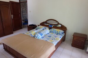 A bedroom with a bed, wooden nightstands, a wardrobe, and a stone-patterned wall.