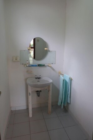 A bathroom with a white sink, a mirror, and a towel rack.