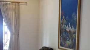 Un salon avec deux canapés, une table basse et un tableau accroché au mur.
