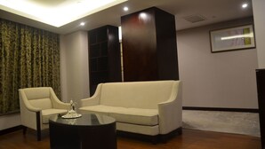 Una habitación moderna con sofá, mesa de centro y cortina estampada.