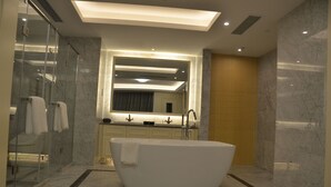 Un baño moderno con una bañera independiente, una cabina de ducha de vidrio y un espejo grande sobre el lavabo.