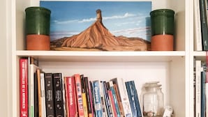 Una estanteria amb diversos llibres, una obra d'art emmarcada i objectes decoratius.