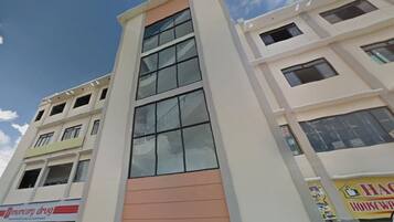 A multi-story building with a central glass facade and a flat roof.