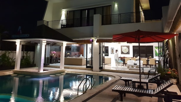 Un hôtel moderne doté d’une piscine, d’un espace extérieur aménagé et d’une entrée bien éclairée.