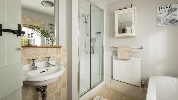 A bathroom with a glass-enclosed shower, a sink with two faucets, a mirror above the sink, and a poster on the wall. - Old Fox Cottage - sleeps 4 guests in 2 bedrooms (Bretforton)