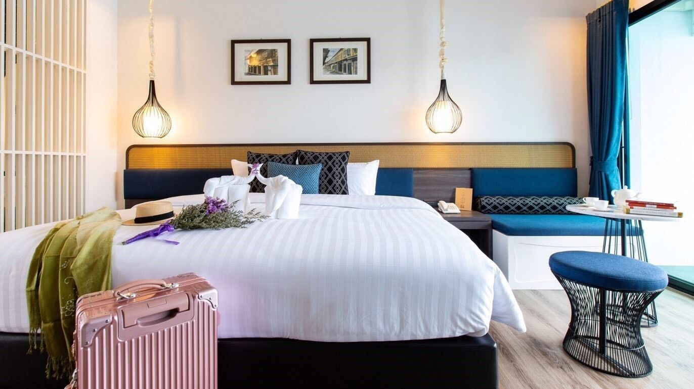 Une chambre d’hôtel dotée d’un grand lit, de tables de chevet, d’un coin salon et offrant une vue sur l’extérieur.
