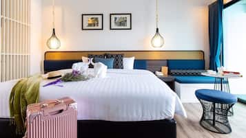 A hotel room with a large bed, bedside tables, a seating area, and a view of the outside.