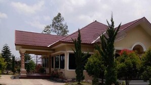 A house with a covered porch, a paved driveway, and a well-maintained lawn. - Aldeoz Dempo Pagar Alam Villa Sumsel (Pagar Alam)