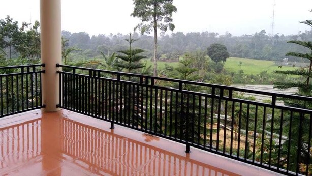 A balcony with a view of a green landscape, including trees and a field. - Aldeoz Dempo Pagar Alam Villa Sumsel (Pagar Alam)