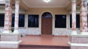 A building entrance with a central door, flanked by columns, and a covered area with steps leading up to it. - Aldeoz Dempo Pagar Alam Villa Sumsel (Pagar Alam)