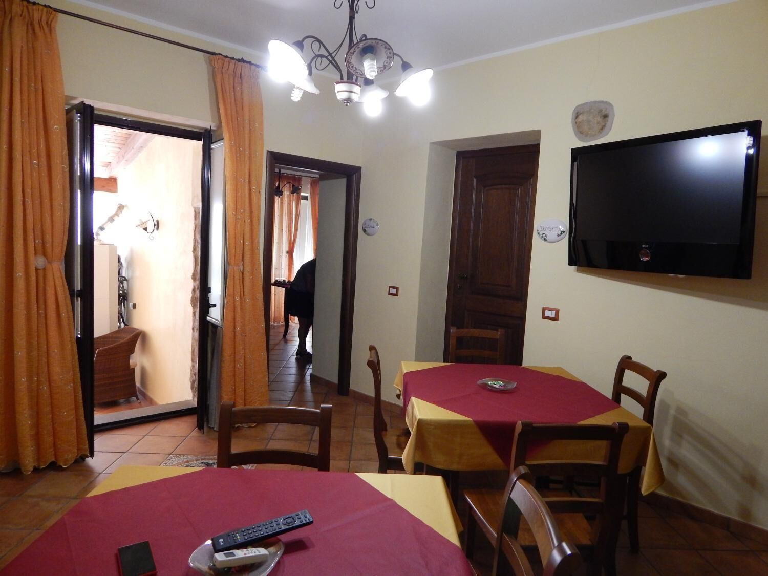 A hotel room with two beds, a TV, a dining table, and a chair.