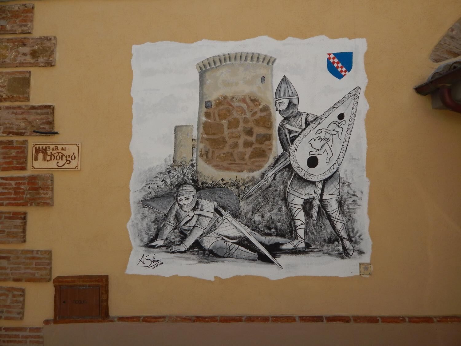 Un mural amb un cavaller i un escut a la paret.