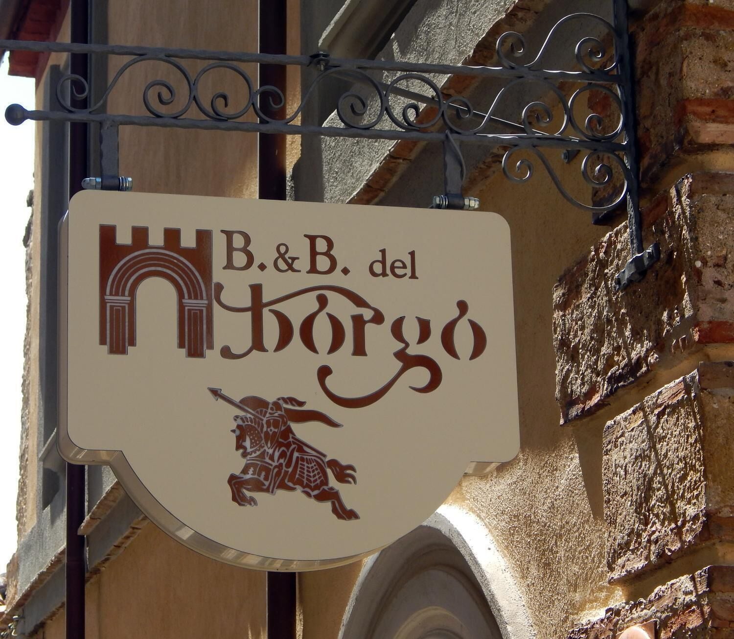 A sign for B&B del Borgo with a horse and castle design.