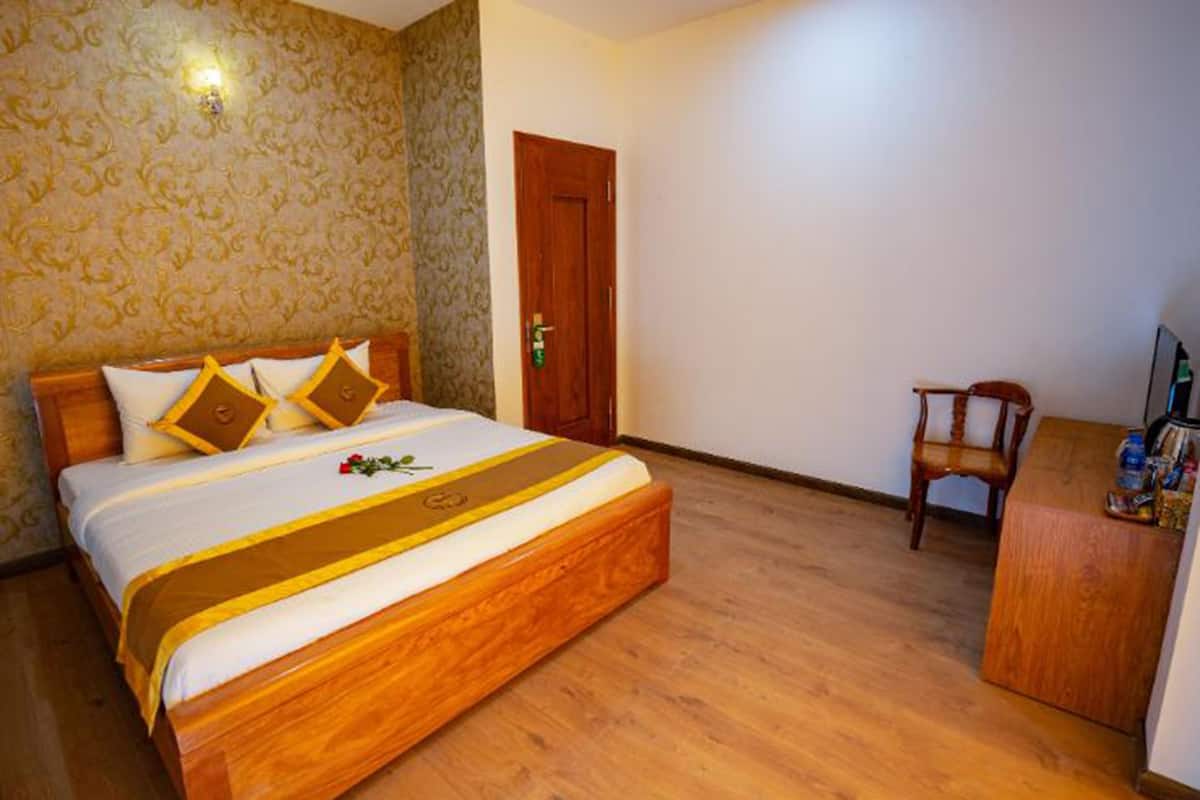 Ein Hotelzimmer mit einem hölzernen Bett, einem Schreibtisch aus Holz und einem Stuhl.