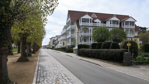 A street lined with trees and a cobblestone sidewalk. - 3-room vacation apartment Villa Parkblick, 55 inch UHD, Blu-ray, renovated in 2024 (Kühlungsborn Ost)