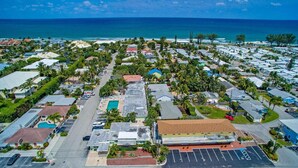An aerial view of a coastal residential area with houses, a swimming pool, and a beach in the background. - Beach studio with pool 200 meters from the beach  (Boynton Beach)