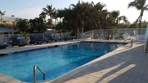 A swimming pool with lounge chairs and a metal railing. - Beach studio with pool 200 meters from the beach  (Boynton Beach)