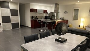 Una cocina moderna con armarios rojo oscuro, una campana extractora de acero inoxidable y un lavavajillas integrado.
