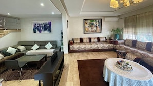 A modern living room with a sofa set, a coffee table, and a TV. - At the heart of Rabat Beaches (Harhoura)