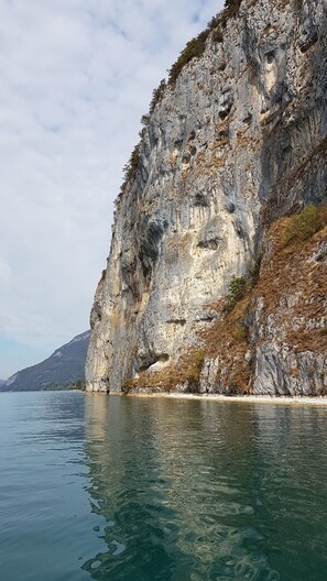 Acantilado costero con vista despejada al mar y una montaña distante.