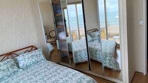A bedroom with a large mirror reflecting the room and a balcony with a view of the sea. - Caravelles palace ***** the most beautiful apartment in Arcachon on the beach (Arcachon)