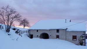 A snow-covered building with a rustic exterior, a wooden fence, and a clear sky. - Gîte du Champ Chequelin - 3 ears 4 stars (Corravillers)
