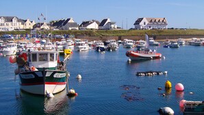 A marina with various boats docked, a few anchored in the water, and houses in the background. - Quiet, 3-star rated house, 800m from beaches and coastal paths (Tregunc)