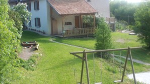 Ein Haus mit Veranda, Schaukel und kleinem Garten.