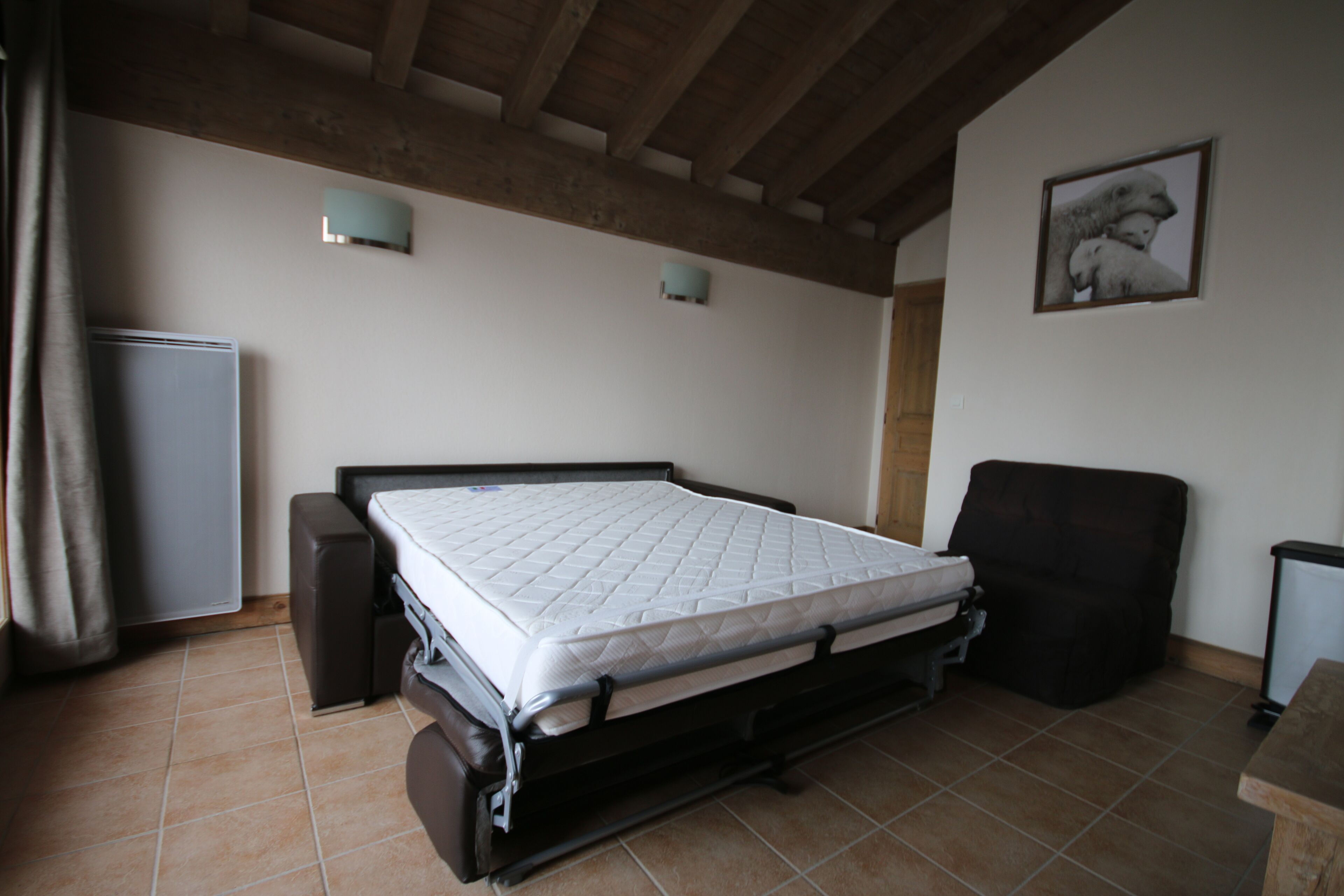 Une chambre à coucher avec un lit, une chaise, un bureau et un tableau au mur.