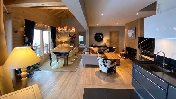 A modern interior with a dining area, kitchen, and living space.