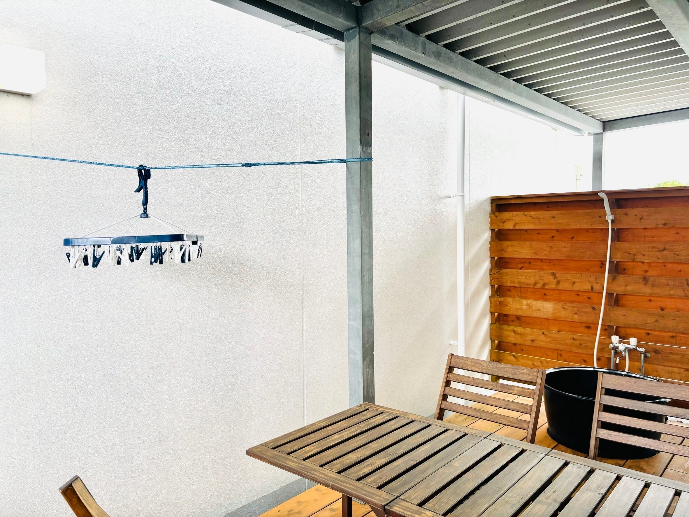 A wooden table and chairs in a room with a white wall and a wooden partition.
