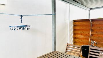 A wooden table and chairs in a room with a white wall and a wooden partition.