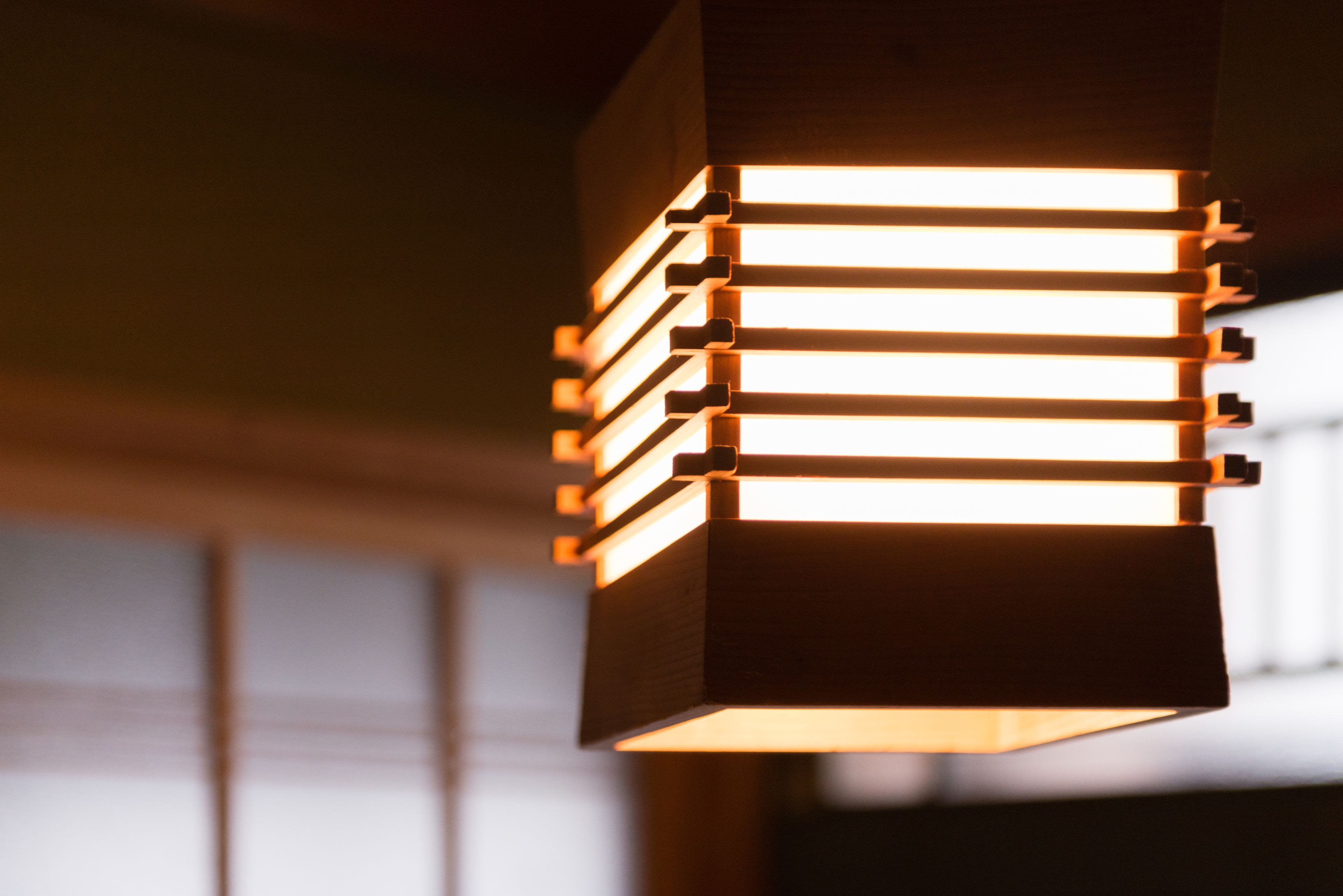 A close-up of a modern, illuminated wall fixture with multiple horizontal light bars.