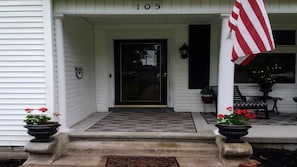 Home 105 features a simple, clean design with a black-framed door and a small porch area.