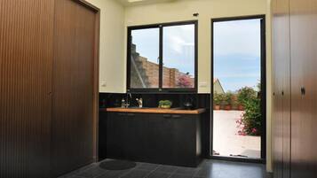 Una cocina moderna con encimera negra, un fregadero y ventana con vistas a un jardín.