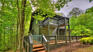 A cabin with a wooden deck and stairs leading to a balcony. - Sans Souci | Pet Friendly (Copperhill)