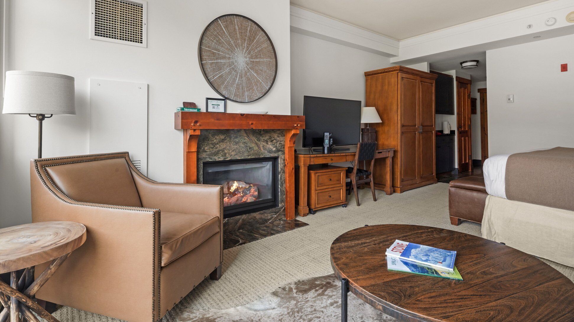 Una sala de estar con chimenea, un sofá, una mesa de centro y un televisor.